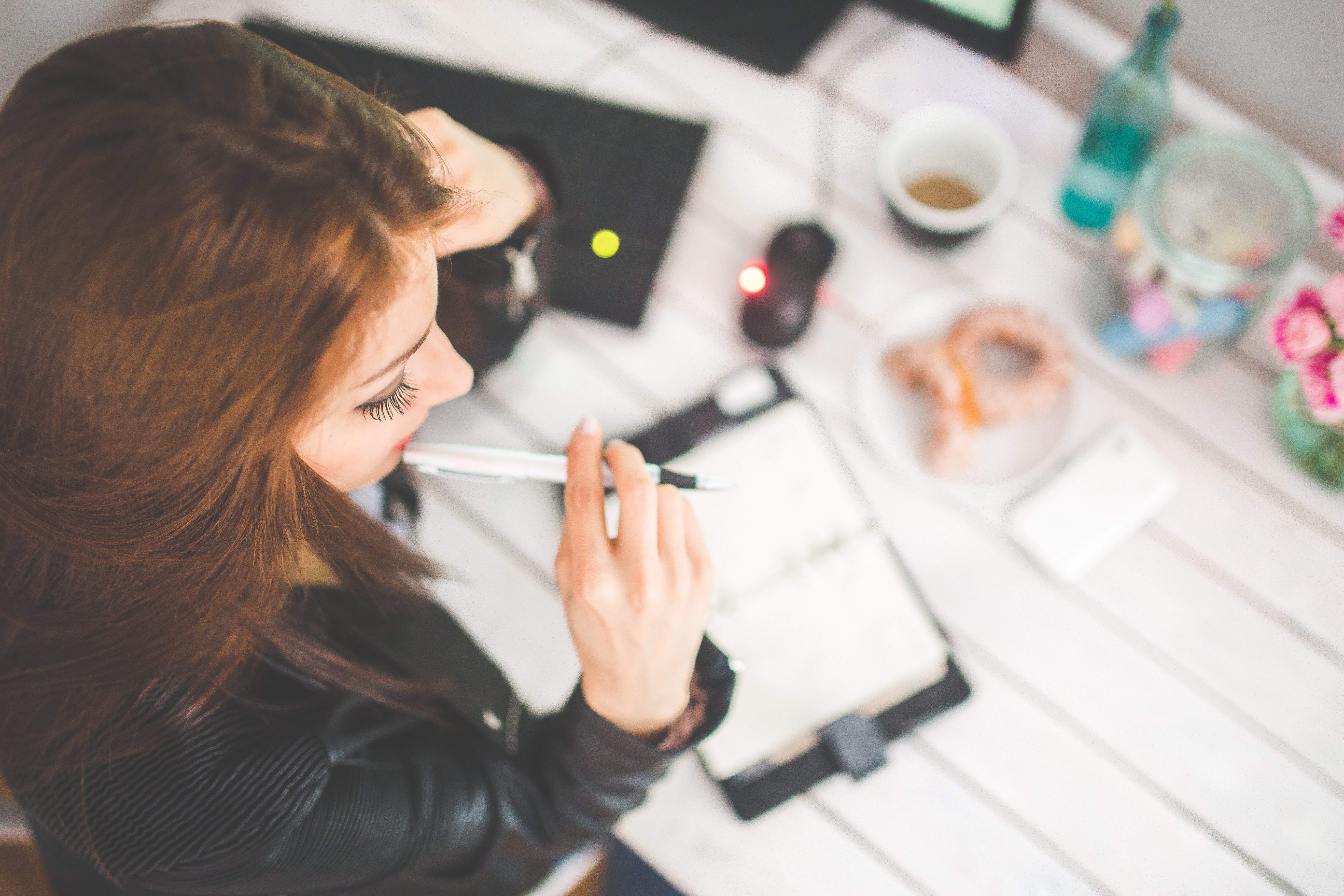 Canva - Young woman thinking with pen while working _ studying at her desk